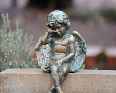 metal statue of a crying angel child